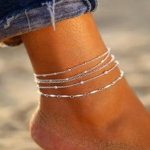  Women's multi-layer anklet on beach, stylish geometric design.