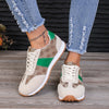 Contrast round-toe flat sneakers in beige and green, paired with distressed jeans and a casual look, perfect for stylish comfort.