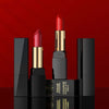 Plush Fashions Gentle Moisturizing Lipstick in vibrant red shades against a bold red background.