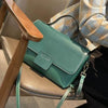 Leather handbag with retro belt decoration and contrast color design.