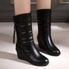 Women's black snow boots with plush design, side zipper, and wedge heel, perfect for style and comfort in winter.