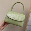 Luxury leather handbag for women with hard handle in green, 17.5cm by 7cm by 11cm.