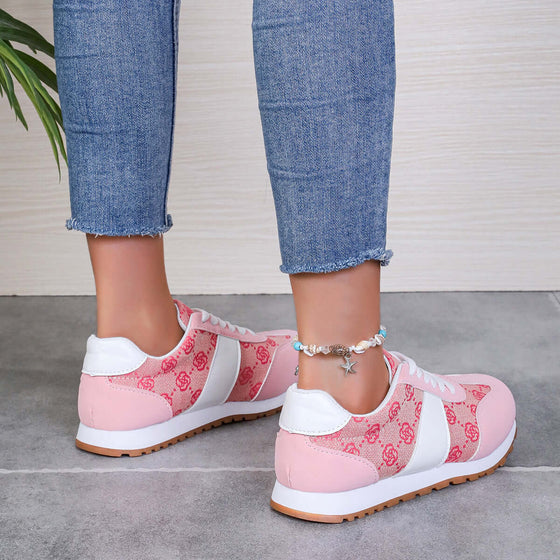 Contrast round-toe flat sneakers in pink with white accents, styled with jeans and ankle bracelet. Comfort and style combined.