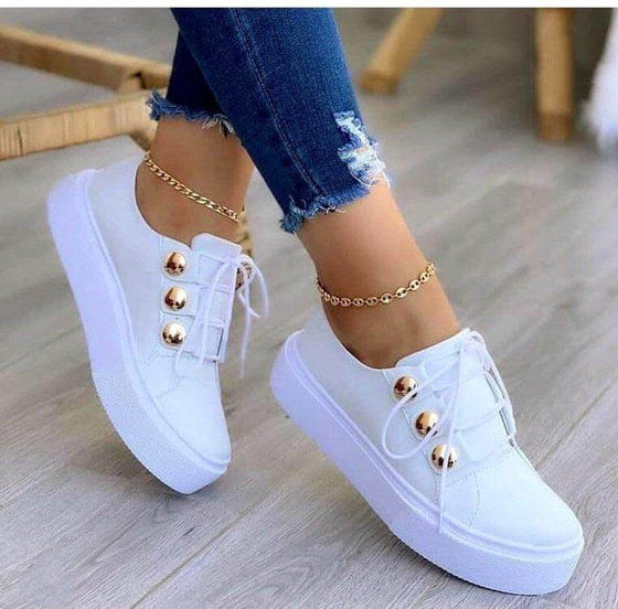 Lace-up flats sneakers with rivet detailing for women in white.