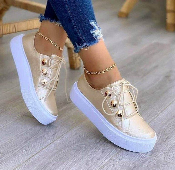 Lace-up flats sneakers with rivet detailing for women.