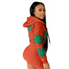 Women's sports two-piece set short suit in vibrant orange with green clover print.