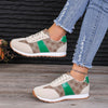 Contrast round-toe flat sneakers with green accents, styled with distressed jeans, showcasing comfort and trendy design.