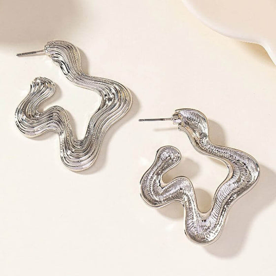 Retro style exaggerated female earrings with geometric design in silver.