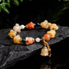 Natural Xinjiang Gold Silk Magnolia Bracelet with Jinsi Jade and orchid beads on black stone.