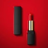 Plush Fashions Gentle Moisturizing and Charming Lip Makeup Lipstick in red shade on a red background.