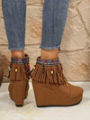 Fringe Suede Wedge Boots with colorful beaded fringe detailing, worn with jeans.