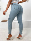 Woman wearing decorative buckle skinny jeans with pockets, showcasing a stylish back view and trendy footwear.