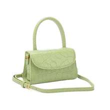  Luxury leather handbag for women in green, featuring a hard handle and modern design.