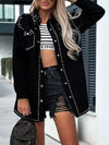 Woman wearing a studded snap down long sleeve denim shacket over a striped crop top and denim shorts. Stylish casual outfit.